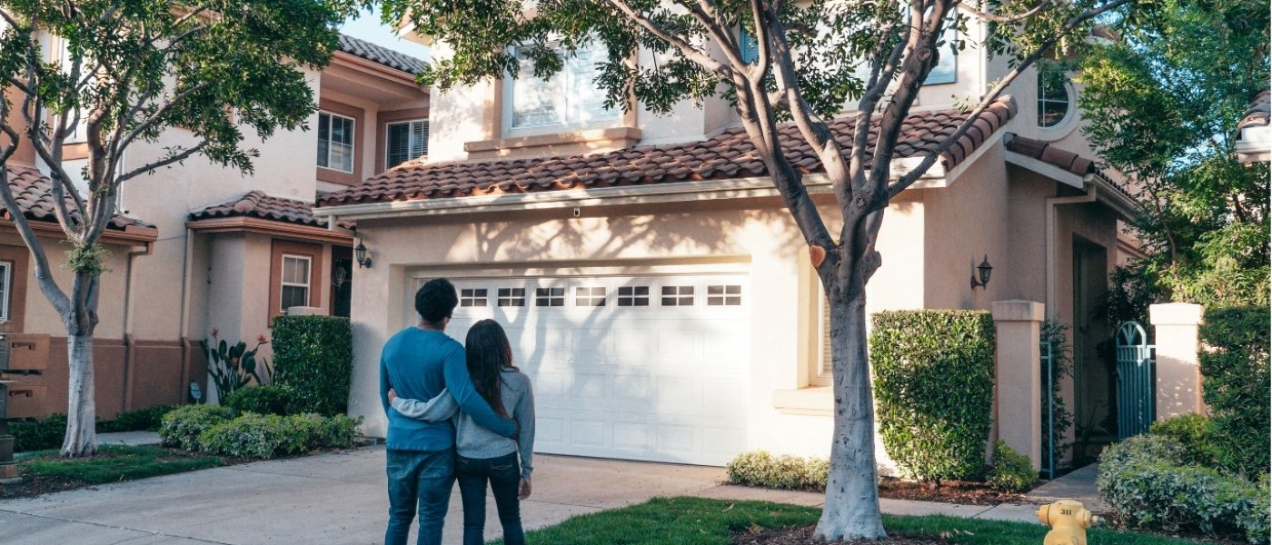 Couple standing out front of their new home